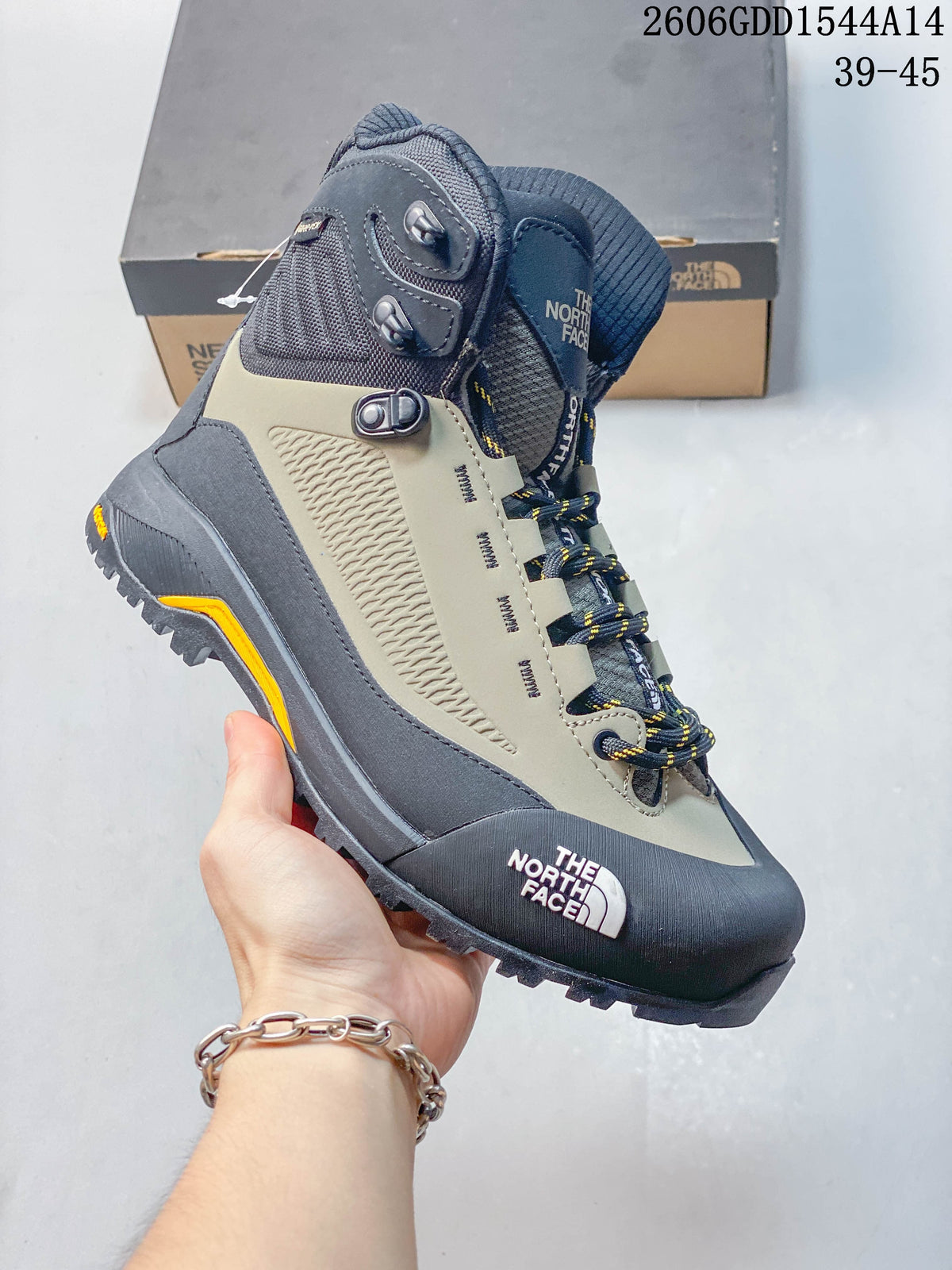Angled view of a Verto Alpine boot with a gray and khaki upper, navy toe guard, and lugged outsole.