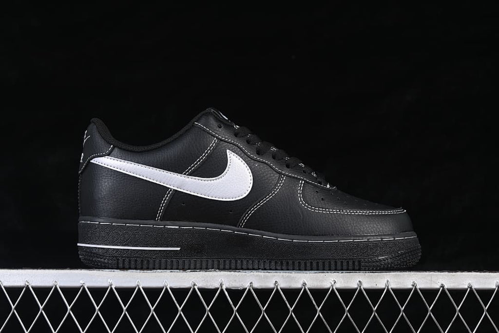 Side view of a black low-top sneaker with a white side accent and contrast stitching