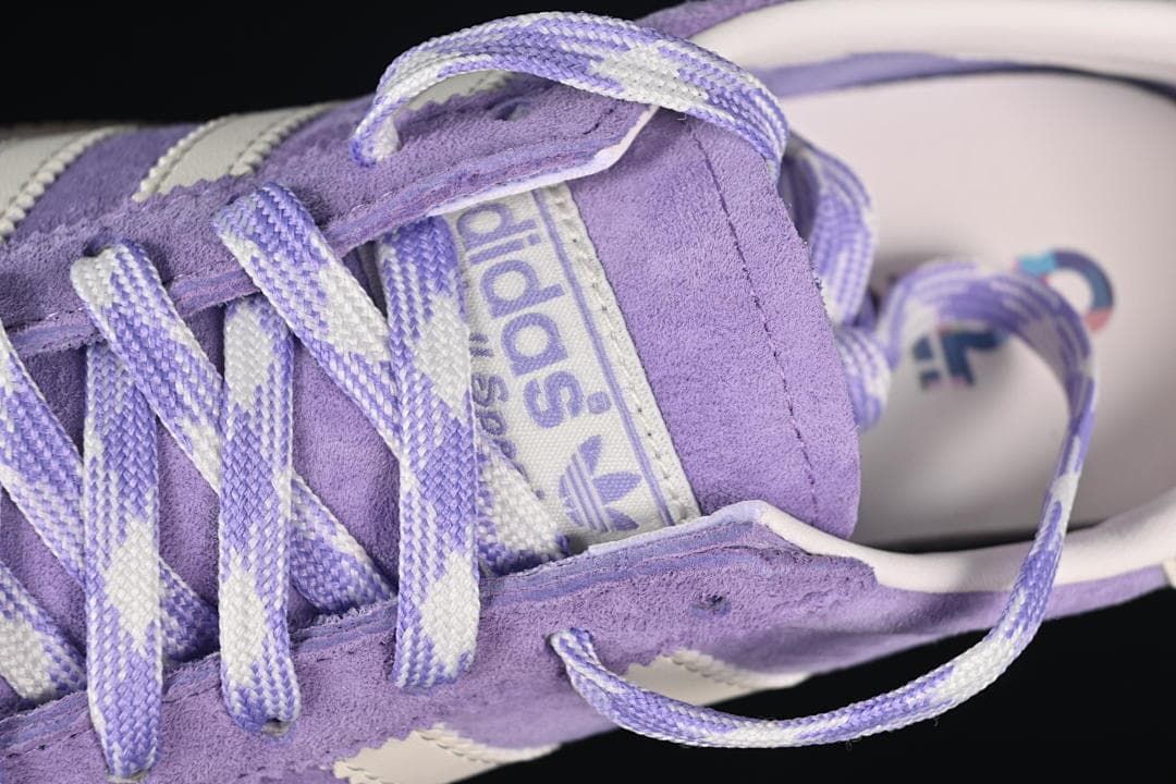 Close-up of the purple-and-cream laces and tongue branding