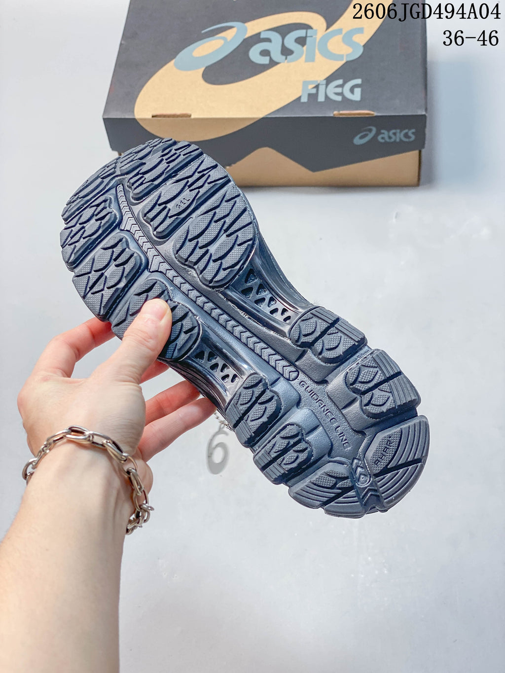 Outsole tread and shoebox shown with the dark gray sneaker