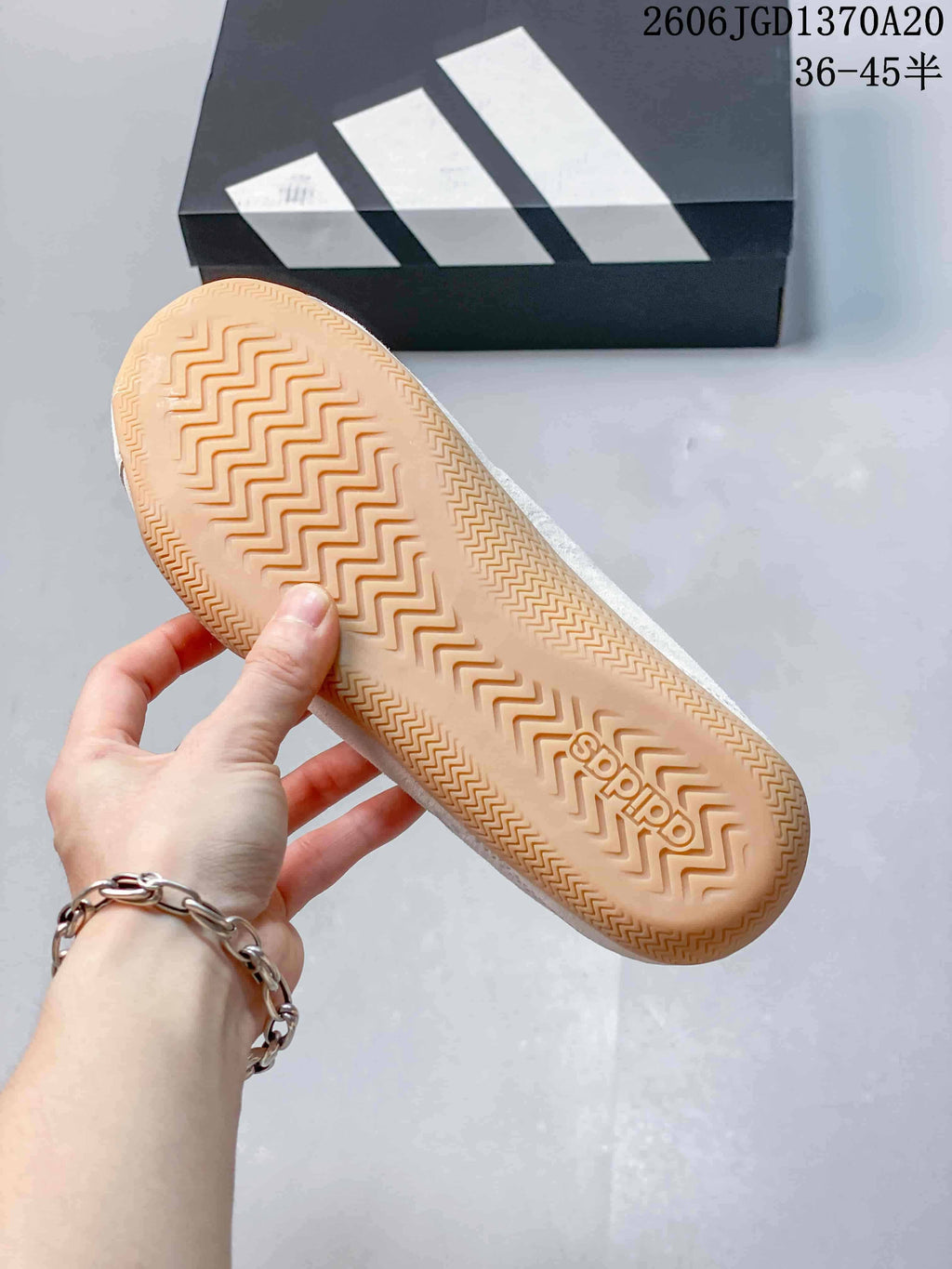 Underside of the shoe showing a gum-colored outsole with patterned tread