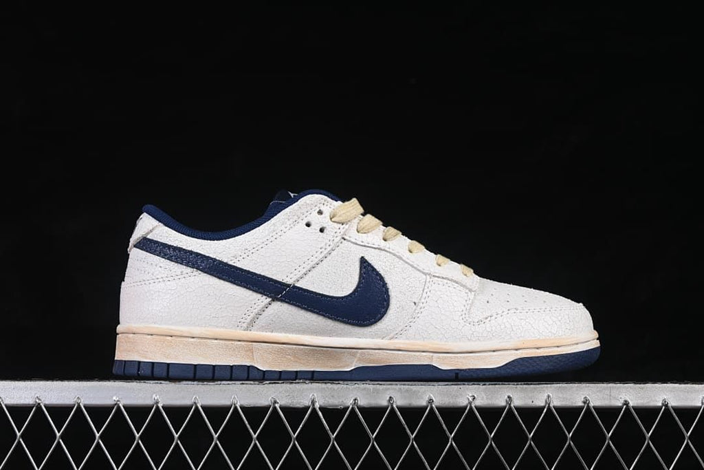 Side profile of a low-top sneaker with navy Swoosh and off-white upper