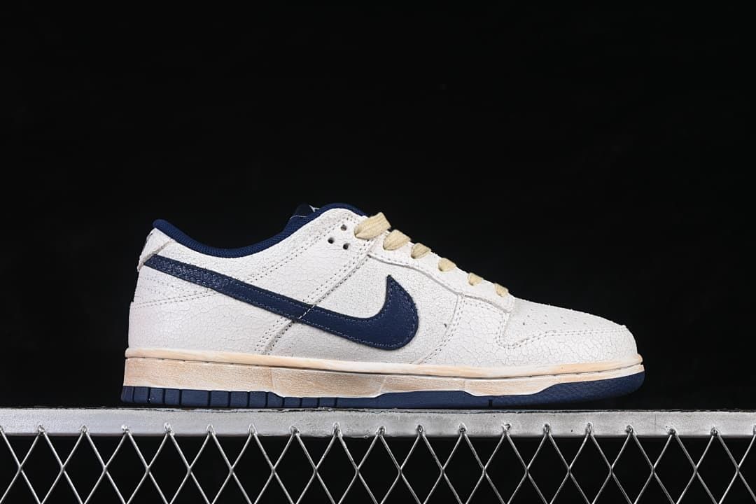 Side profile of a low-top sneaker with navy Swoosh and off-white upper