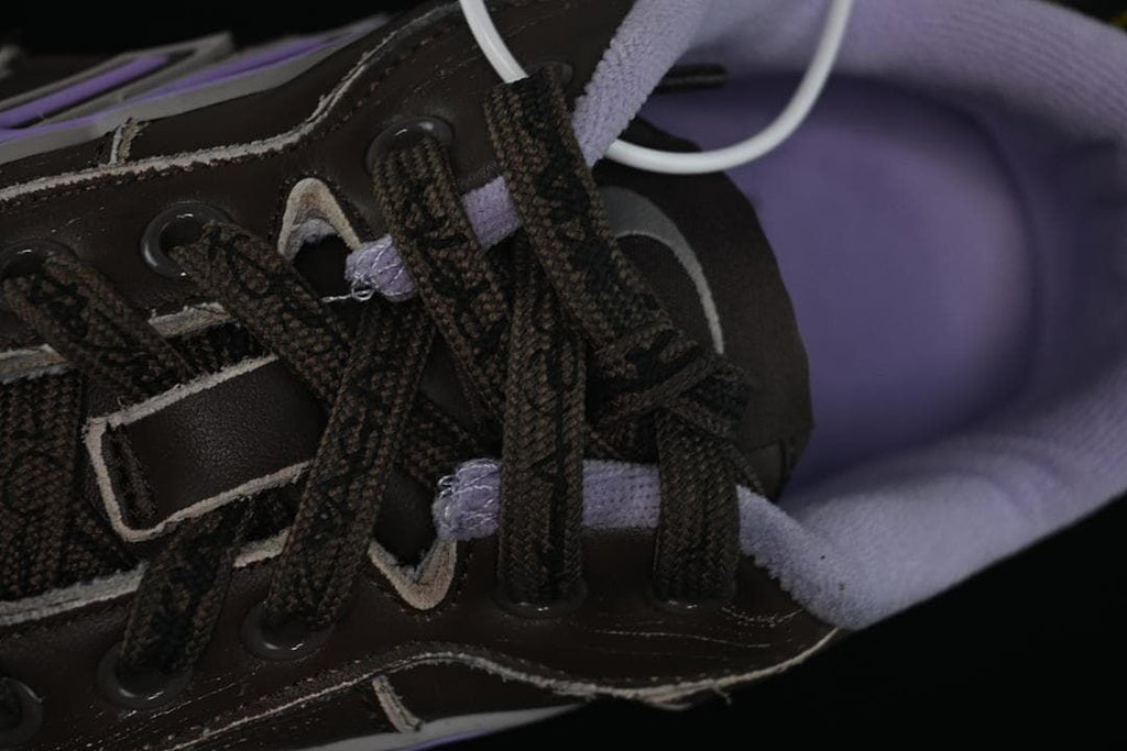 Close-up of the dark laces, eyelets and lavender lining