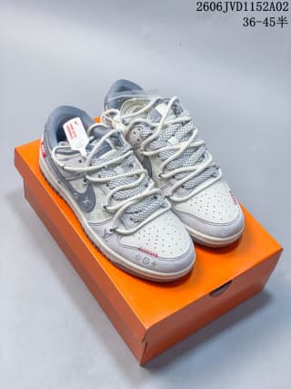Pair of gray and white low-top sneakers displayed on an orange Louis Vuitton box, showing patterned panels and red accents.