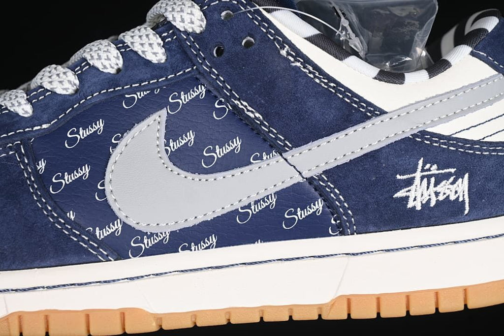 Close-up of the grey side Swoosh, navy overlays, and repeating script pattern