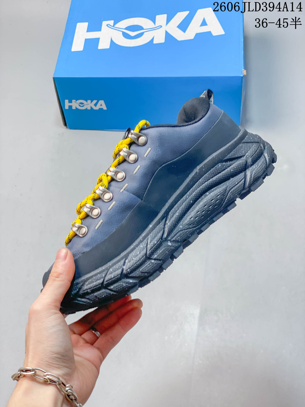 Side view of a blue-gray low-top shoe with yellow laces and a rugged-looking outsole.