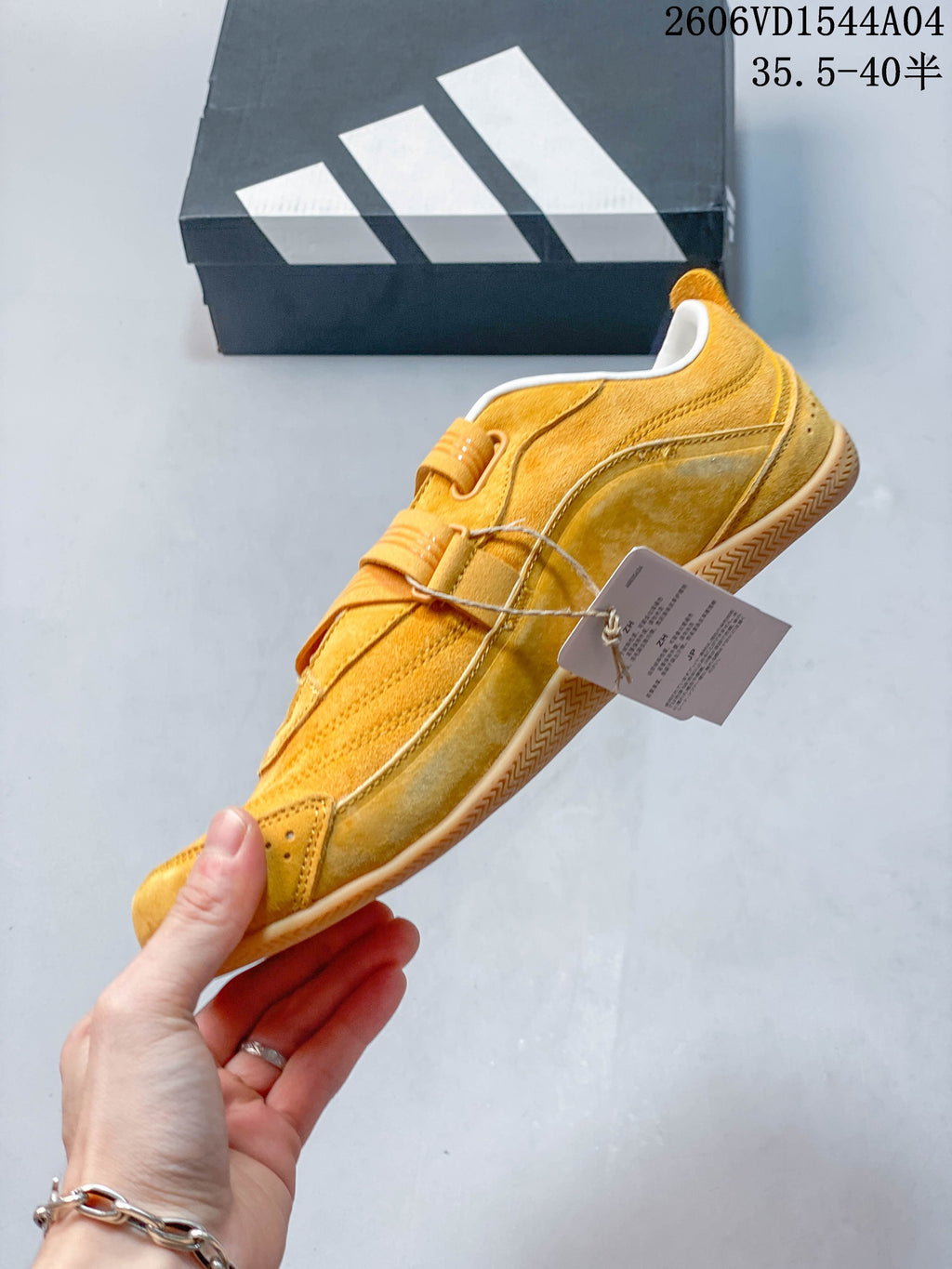 Side view of a golden yellow low-top sneaker with layered panels and a strap-and-lace closure.