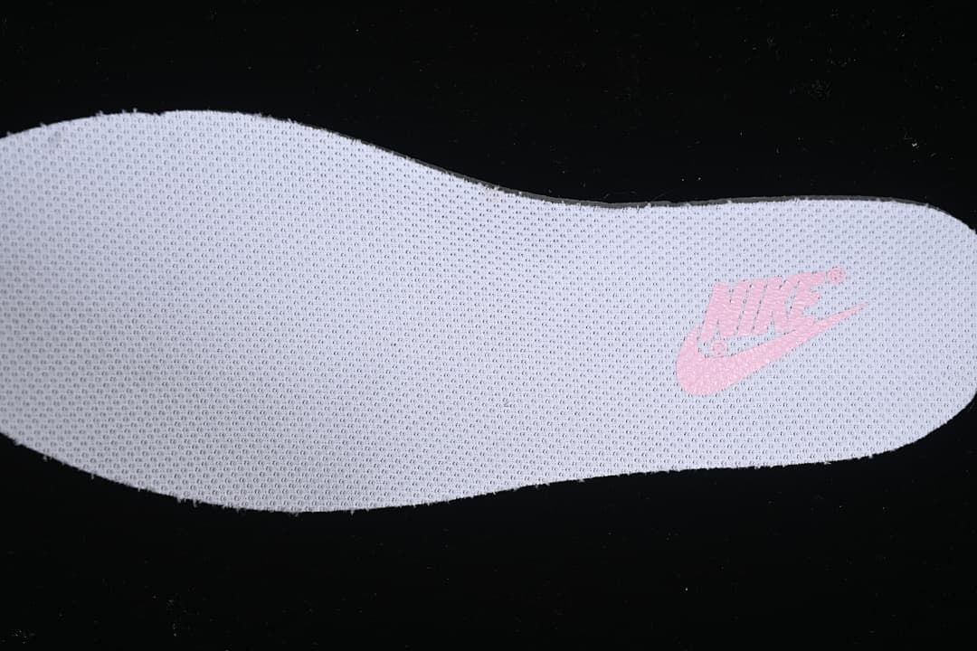 Close-up view of a light-colored insole with pink branding