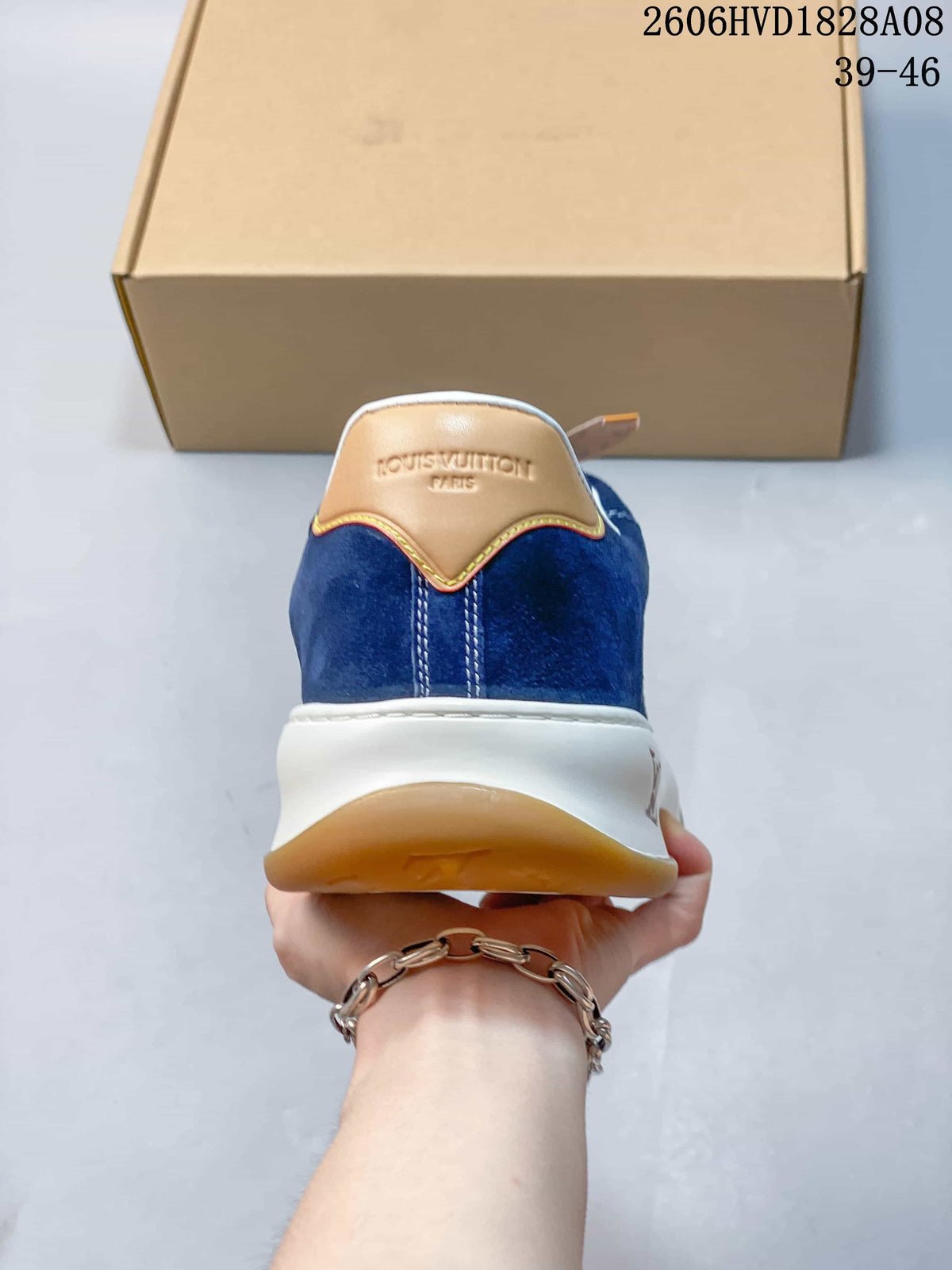 Rear view of a blue sneaker with tan-colored heel detail and white midsole
