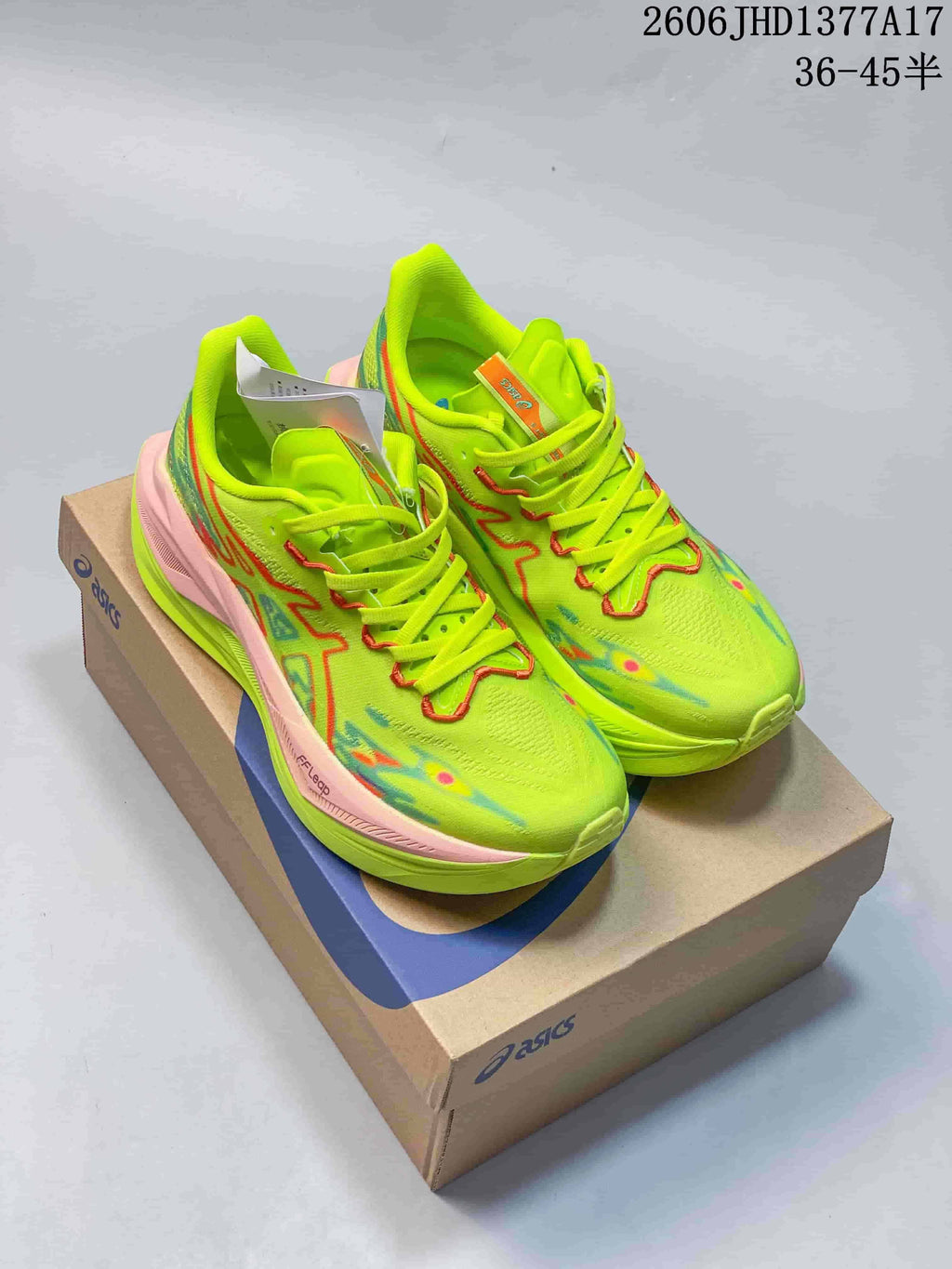 ASICS Megablast shoes in neon yellow with pink and multicolor accents, shown on a shoebox