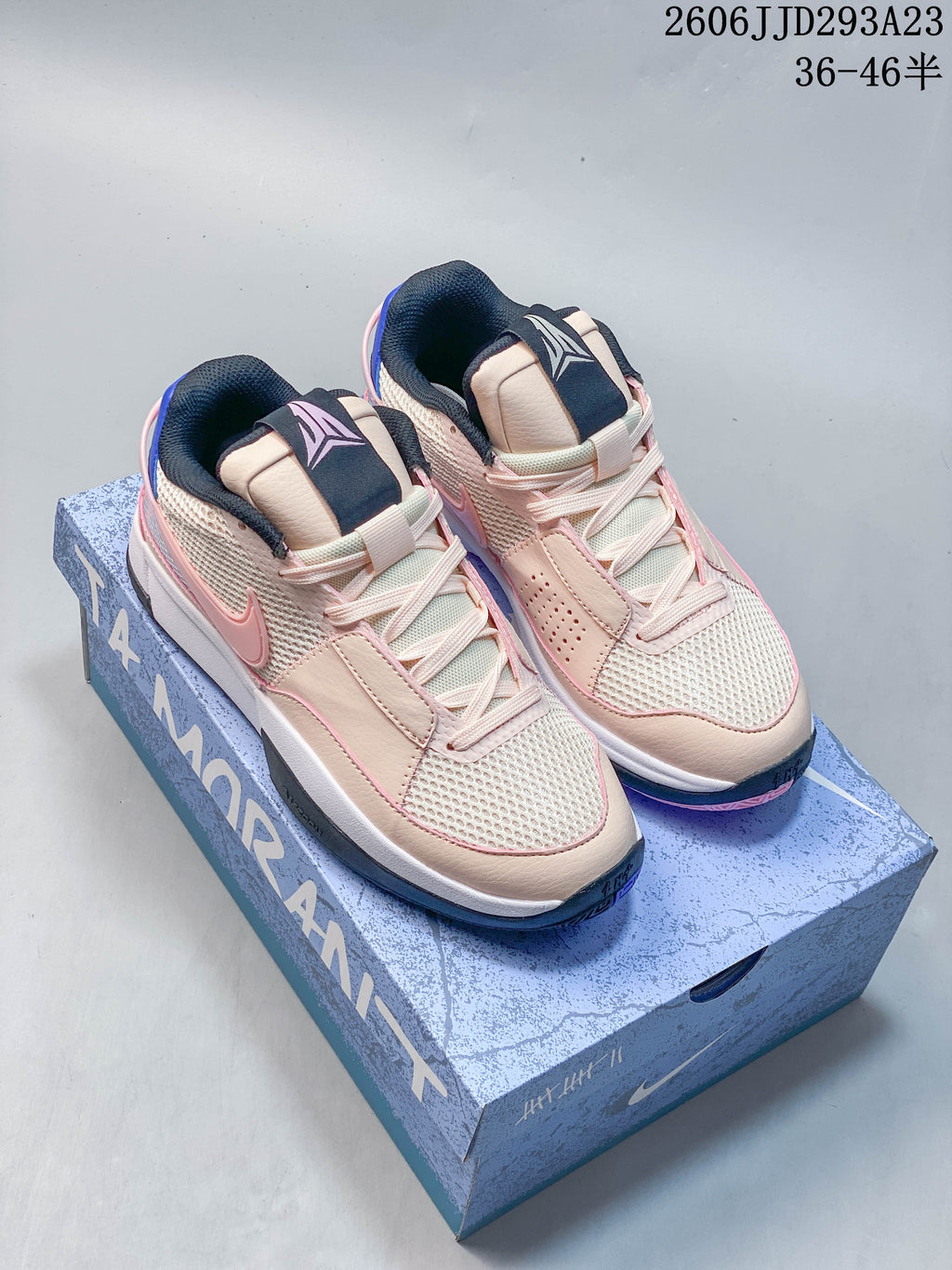 Pair of pale pink and cream Nike Ja 1 EP basketball shoes with blue accents, shown on the shoe box.