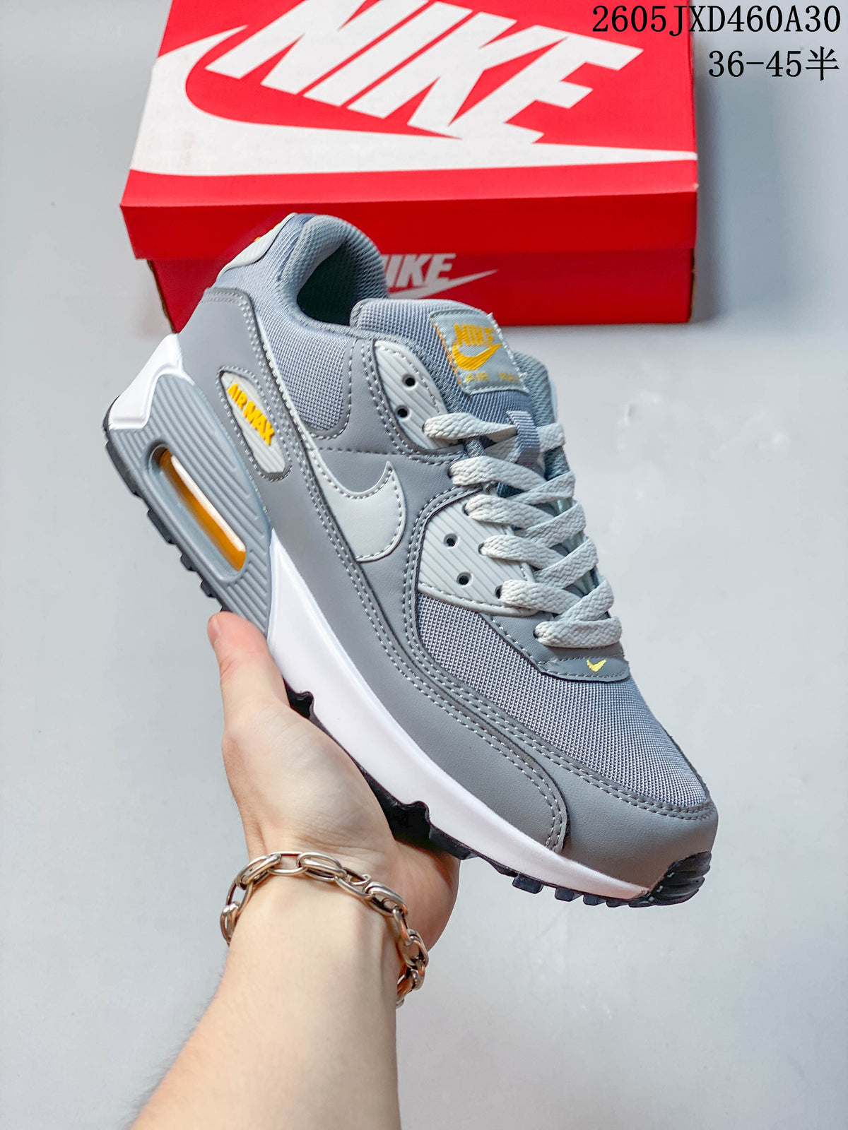 Gray Nike Air Max 90 sneaker with yellow accents