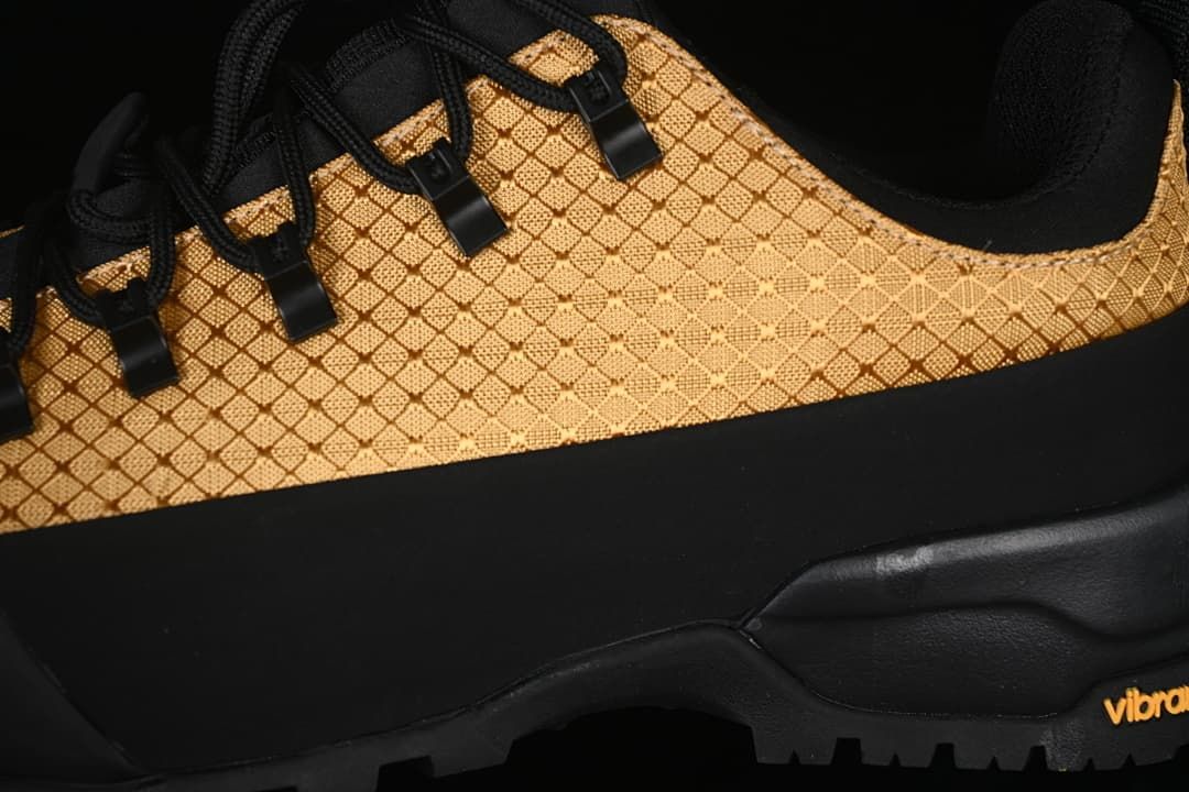 Close-up of the gold patterned upper, black overlays and lugged outsole