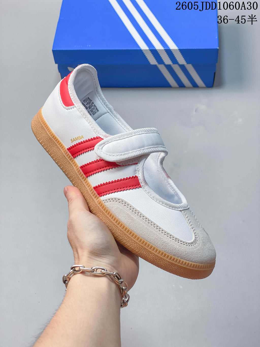 Angled side view showing the Samba marking, red stripes, strap closure, and gum-colored sole