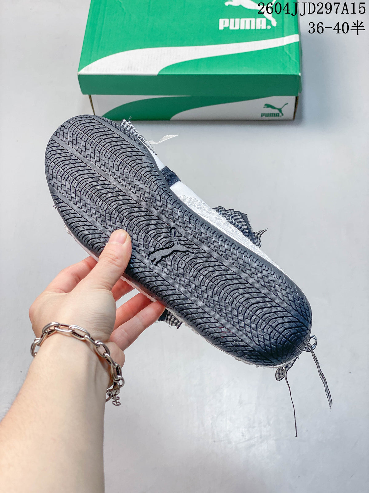Close-up of the patterned dark outsole on a white gingham-trimmed flat.