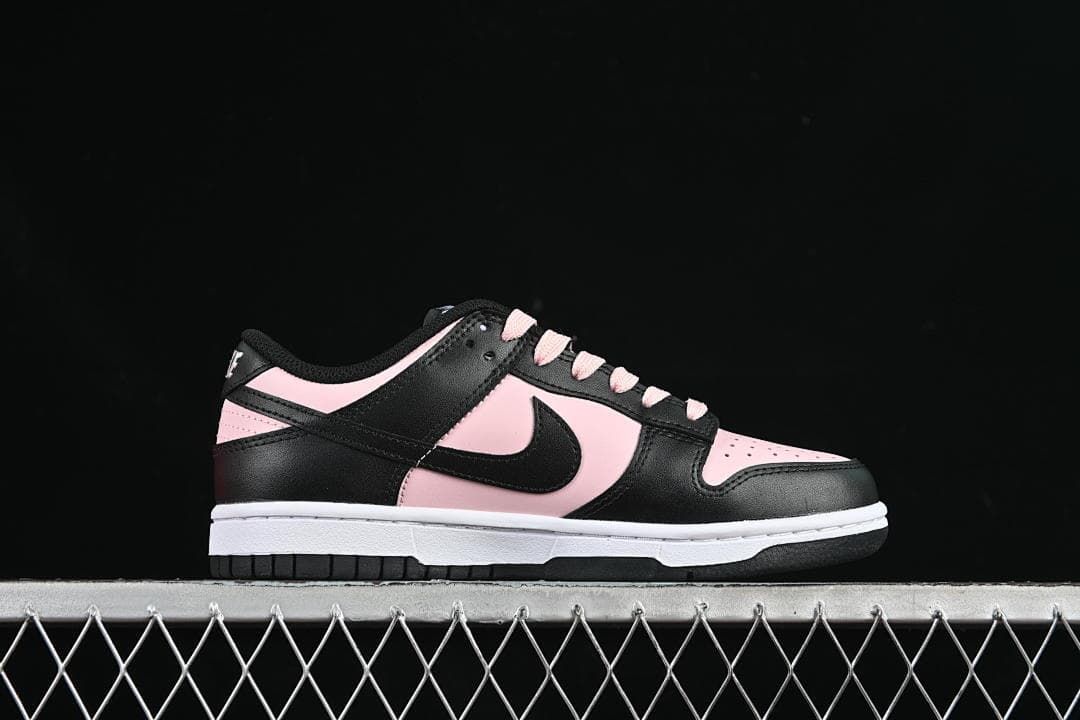 Side profile of a black and pale pink low-top Dunk sneaker