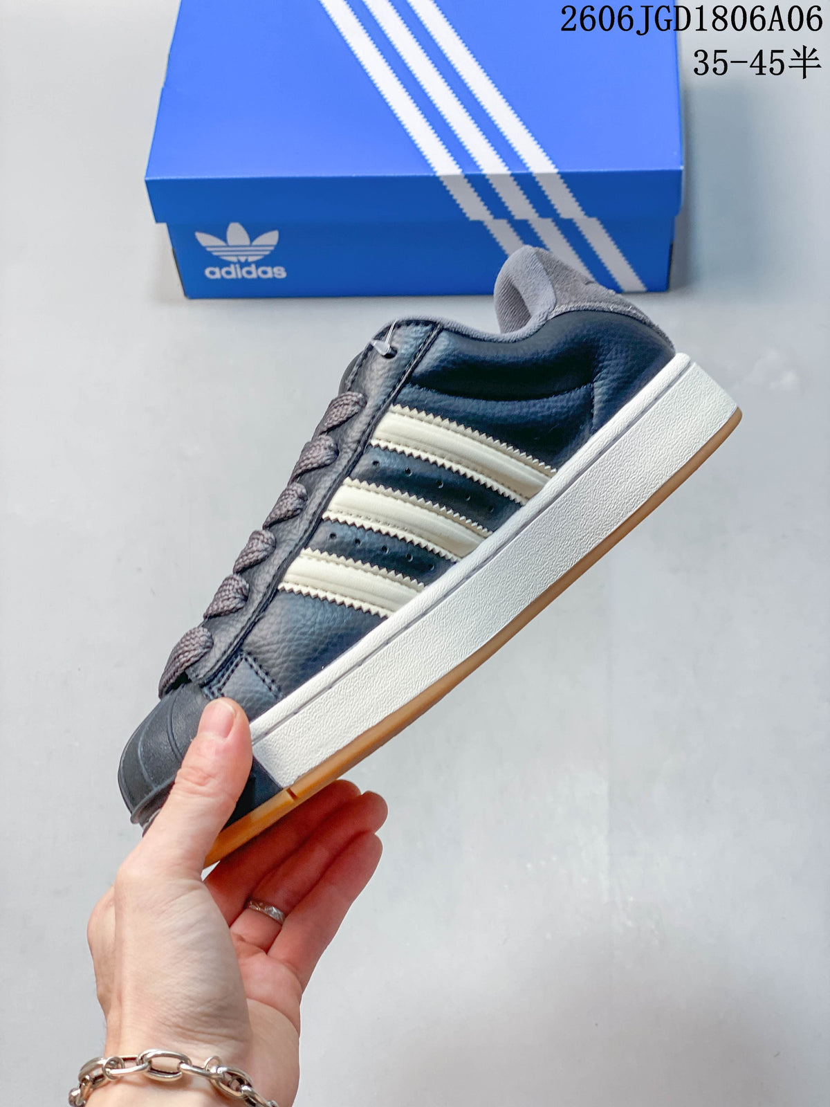 Side view of the sneaker showing off-white stripes, a dark grey upper, and a gum-colored outsole.