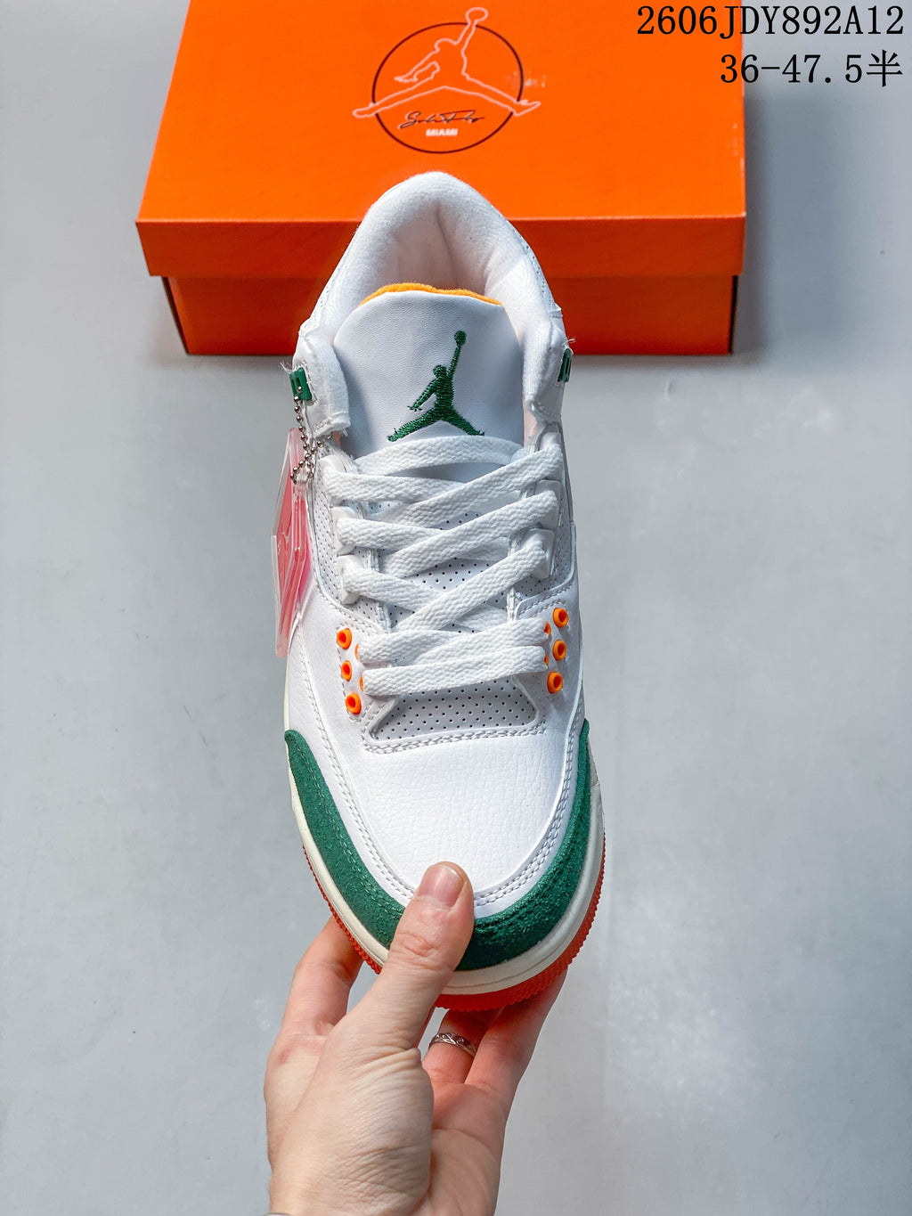 Top view of a white Jordan Air Jordan 3 Retro sneaker with green and orange accents