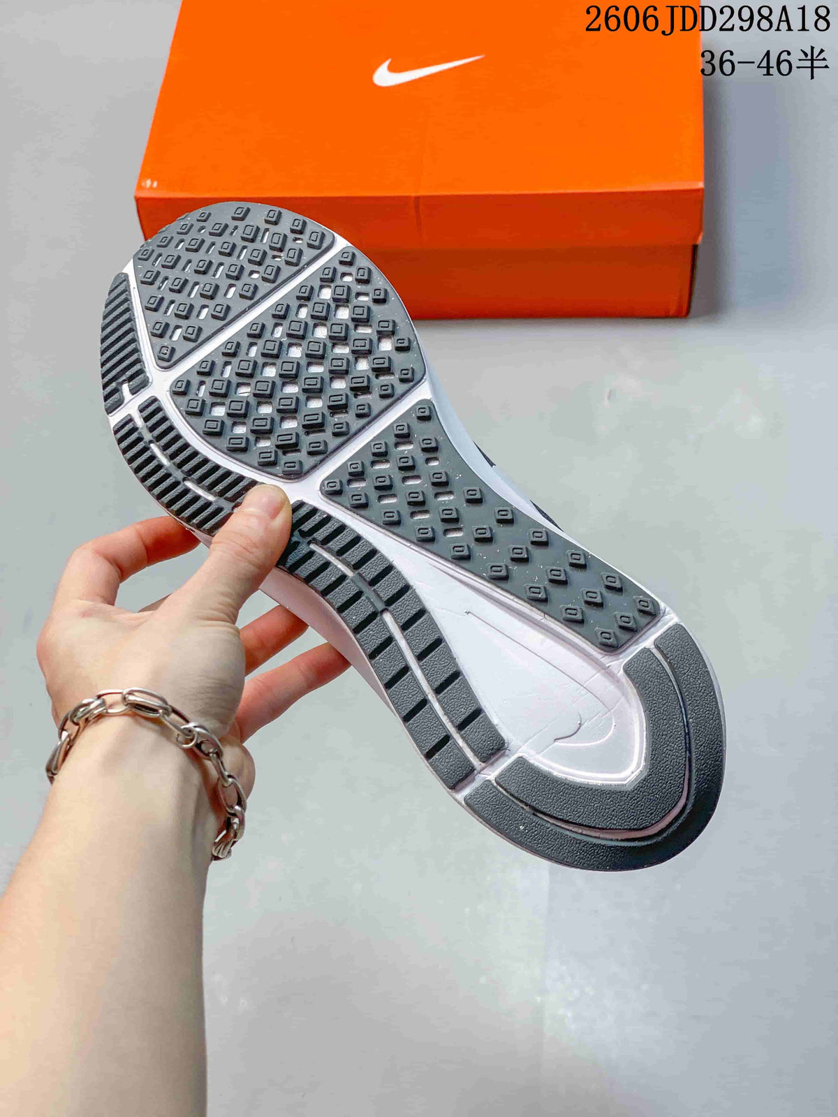 Close-up of the patterned outsole on a gray Nike running shoe