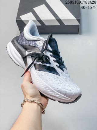 White and gray lace-up training shoe with dark side accents and a light-colored sole; box label shows 40–45.