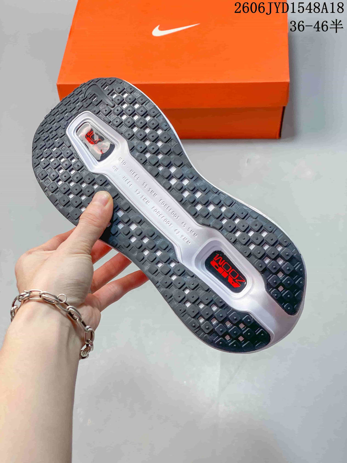 Underside view showing the running shoes' patterned black outsole.