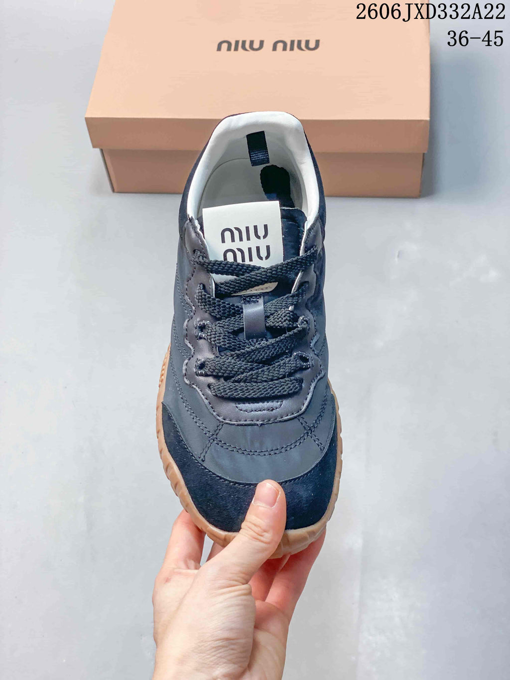 Front view highlighting the rounded toe, lace-up fastening, and layered gray and navy panels.