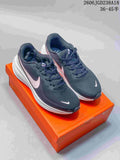 Pair of charcoal Nike Vomero 18 running shoes with pale pink Swoosh details on an orange box