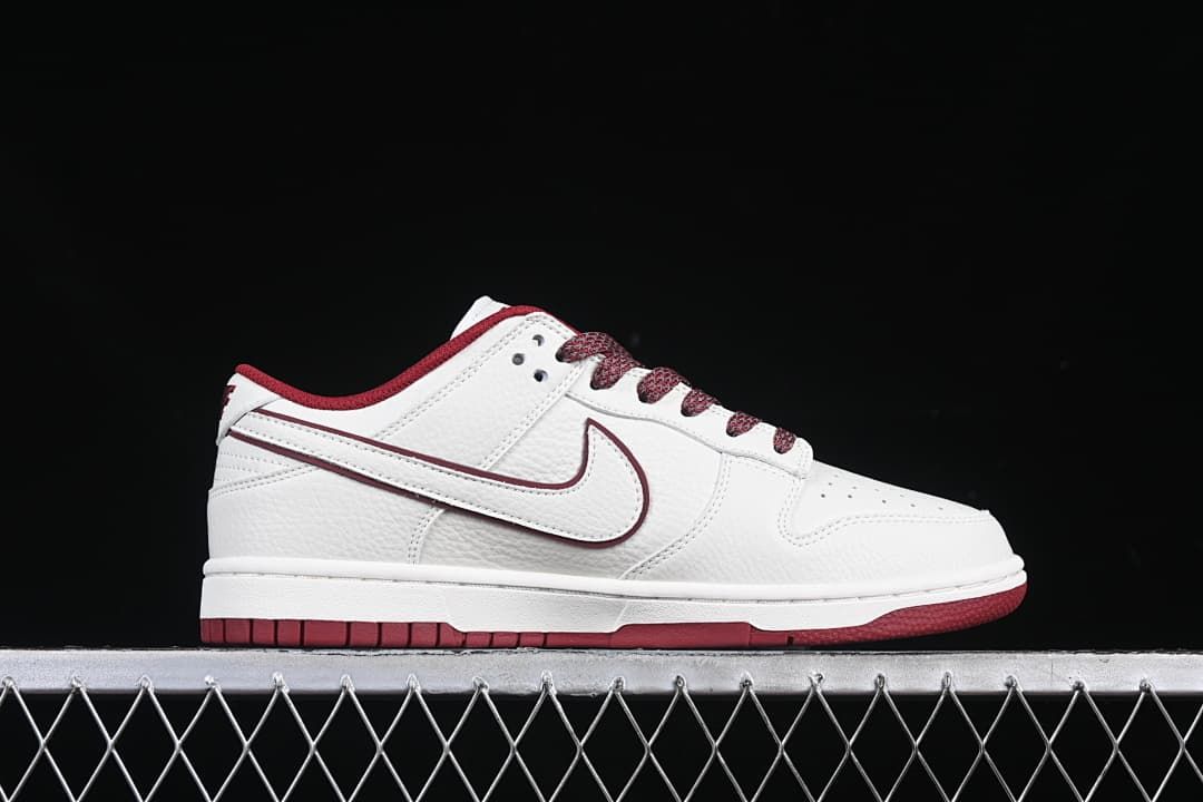 Side profile of a white and burgundy low-top sneaker