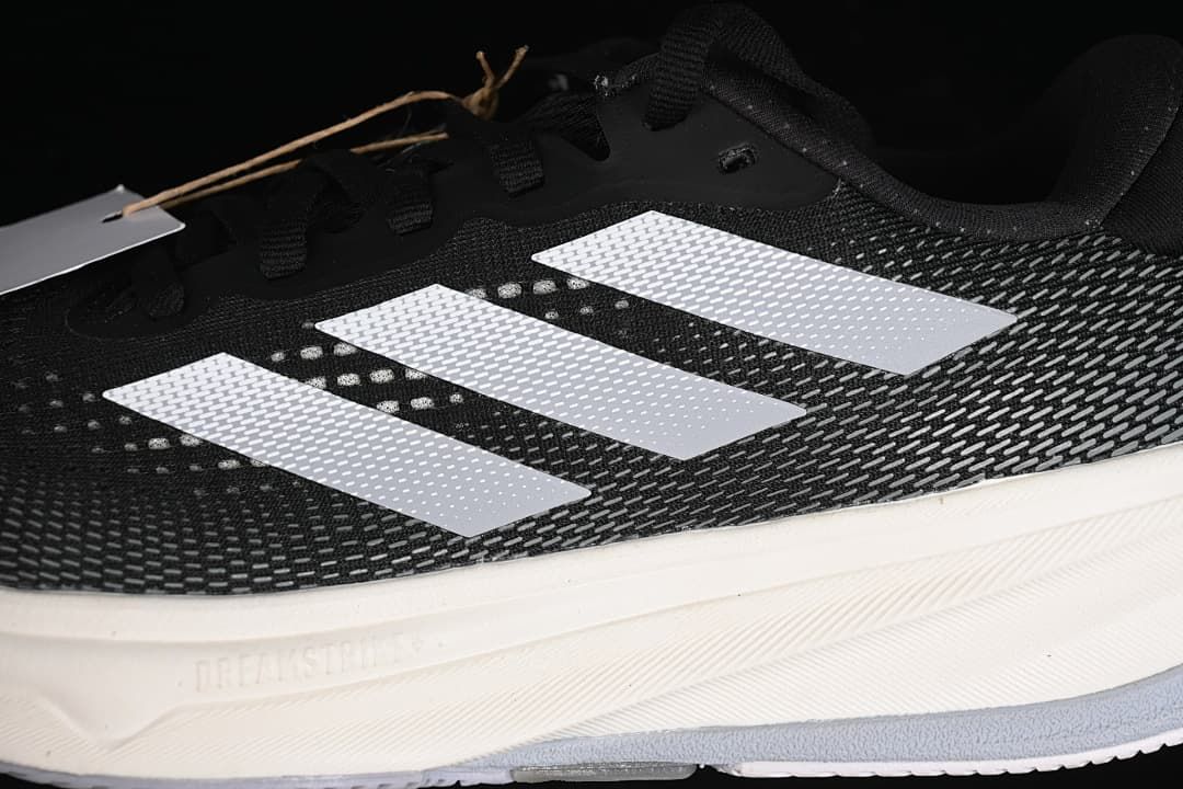 Close-up of the patterned black upper, white stripes and midsole.