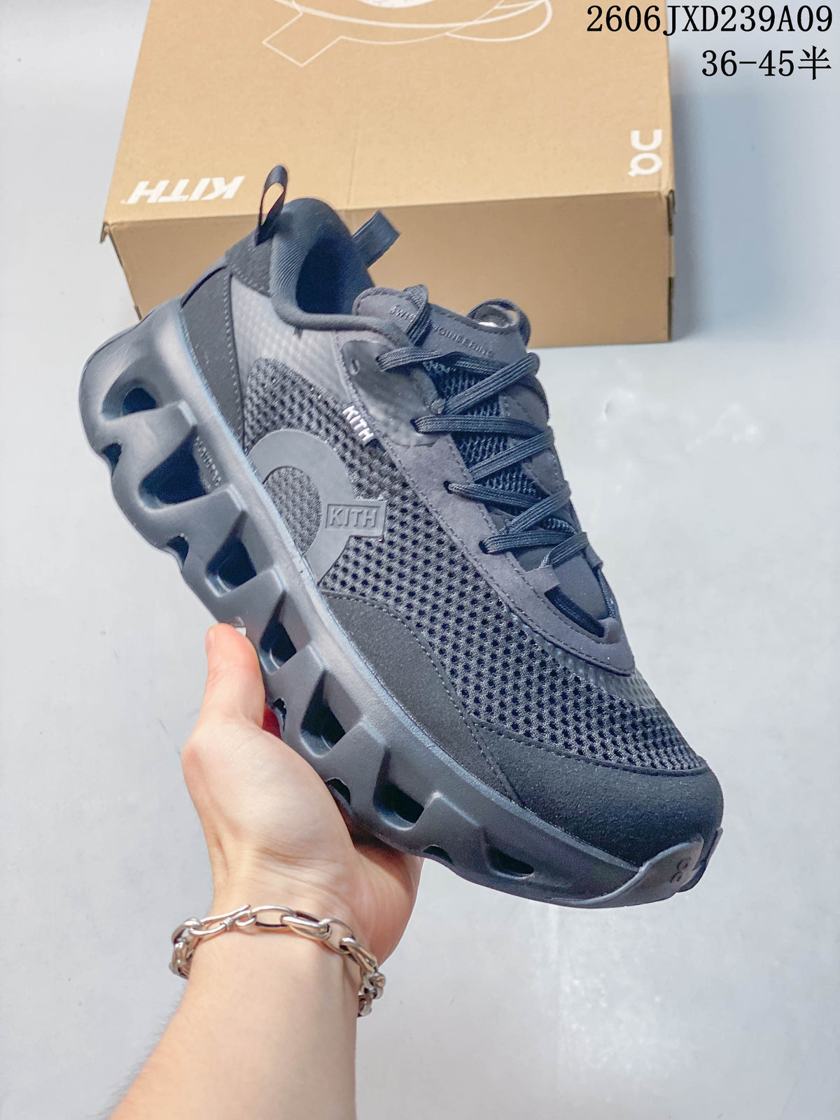 Angled side view showing the charcoal shoe's upper, logo details, and sculpted sole.