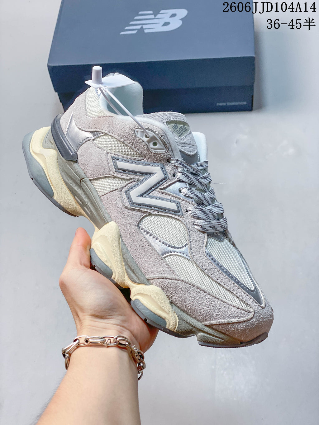 Pale gray and taupe New Balance 9060 sneaker shown at an angle.