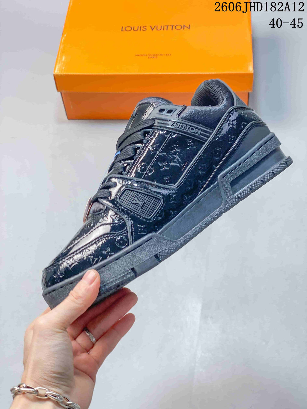 Side view showing the patterned panels and branding on a dark navy Louis Vuitton Trainer sneaker