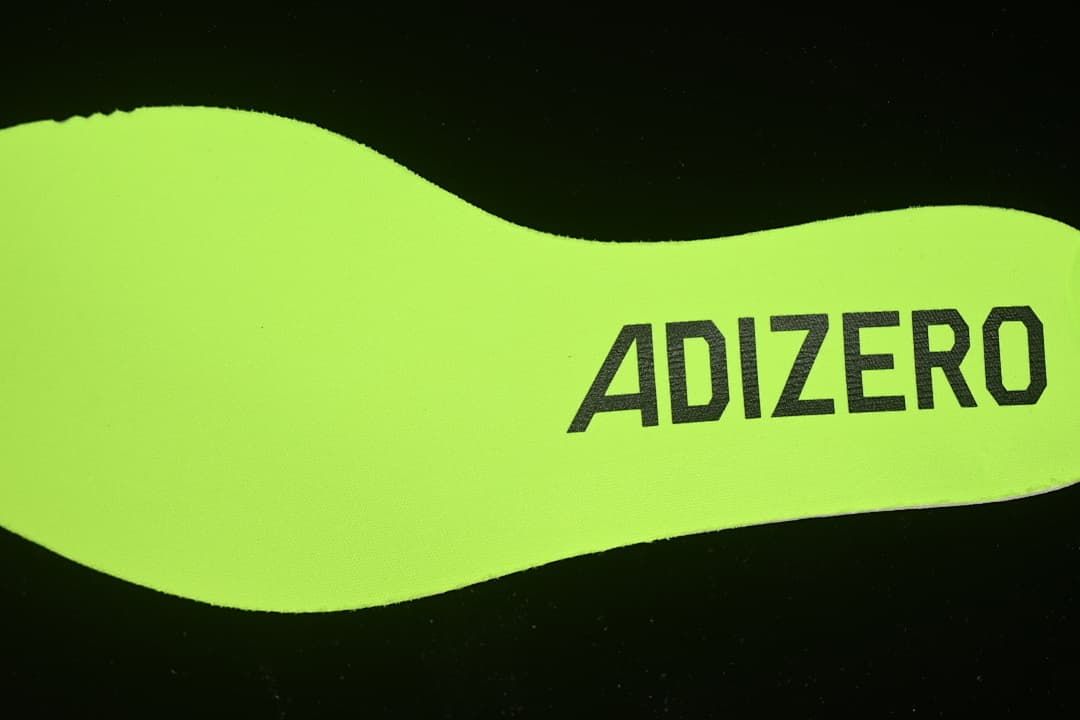 Close-up of neon yellow insole marked Adizero.