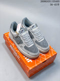 Pair of grey and white Nike Air Force 1 low-top sneakers with patterned laces and a hanging charm