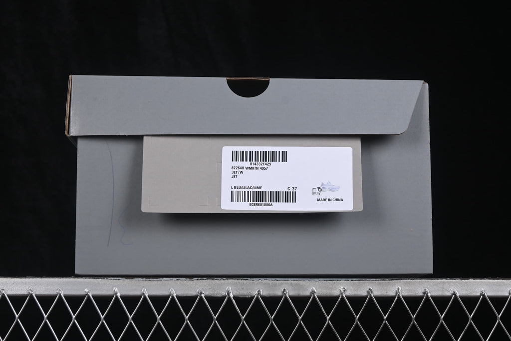 Gray shoe box with a label showing Jet, WMRTN 4957, L BLU/LILAC/LIME and size C 37.