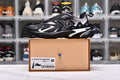 Black and white Runner Tatic sneaker displayed on a labeled box