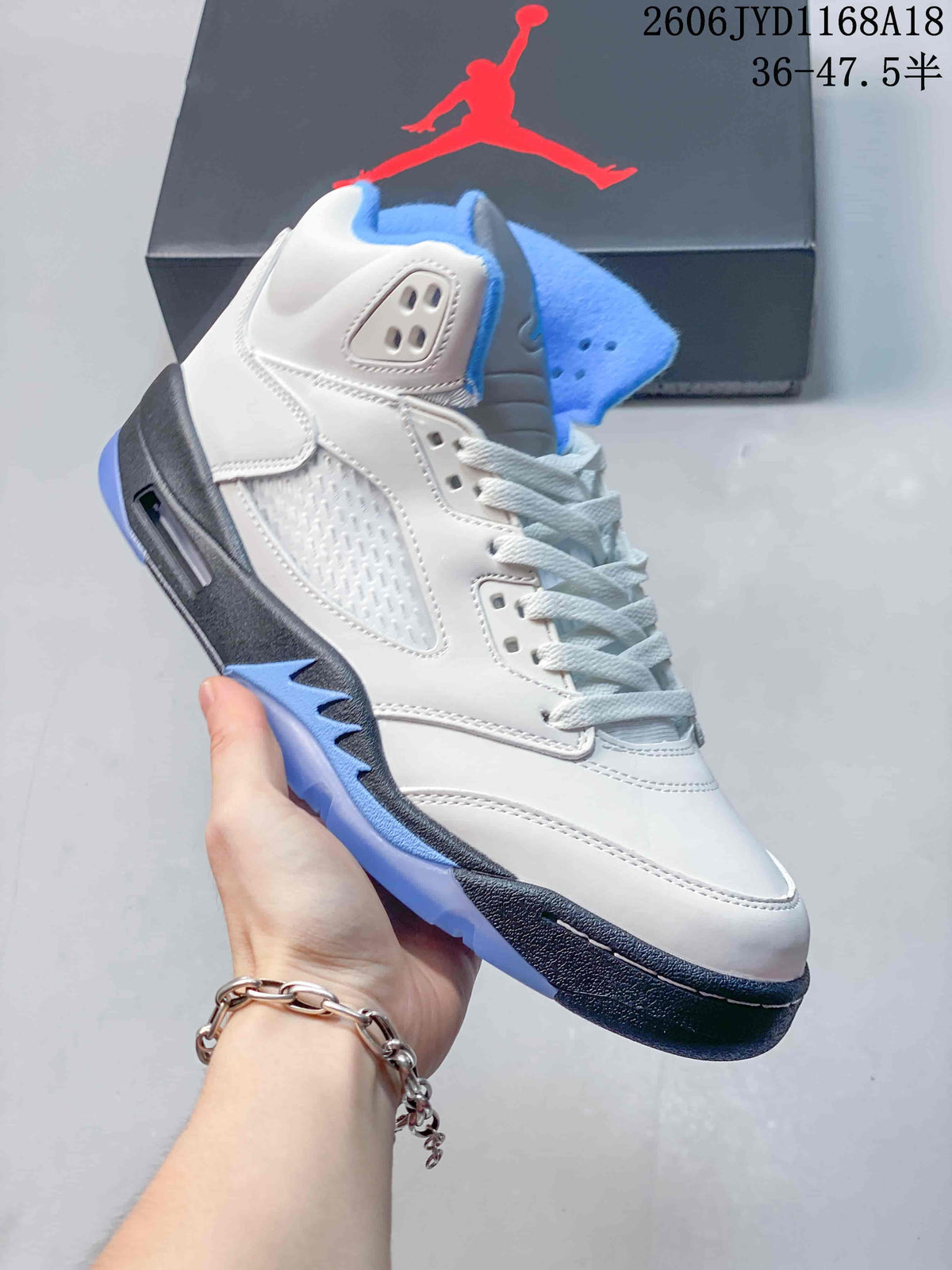 Side profile of a white high-top sneaker with blue and gray accents