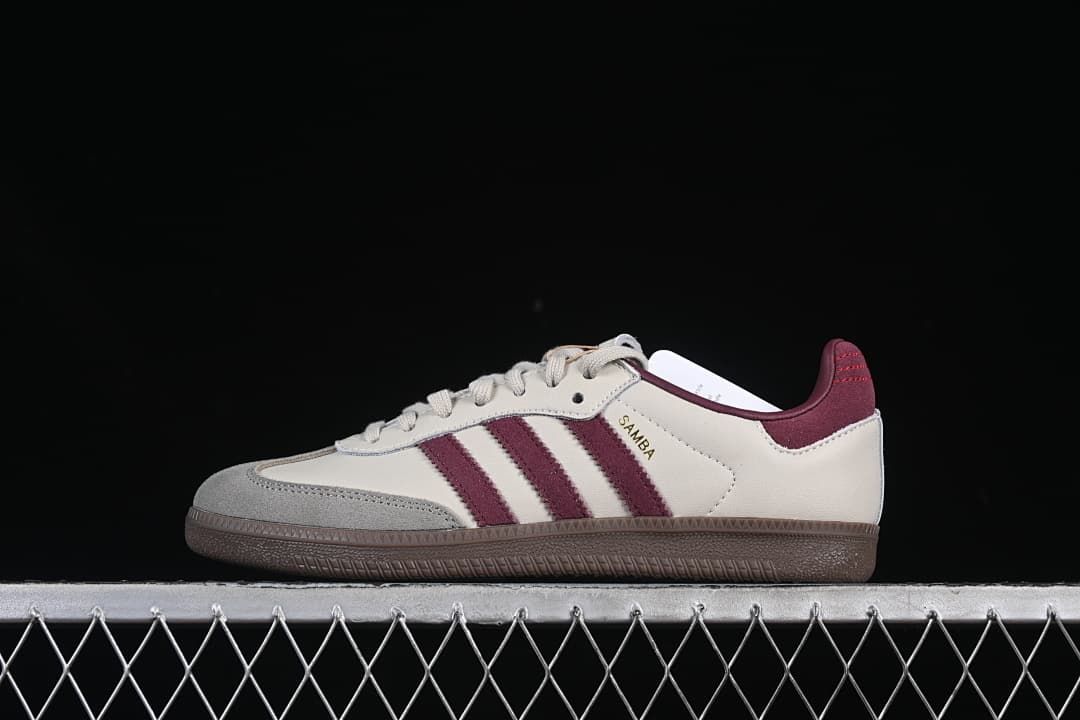 Side view of the cream Adidas Samba OG sneaker with burgundy stripes and brown outsole.