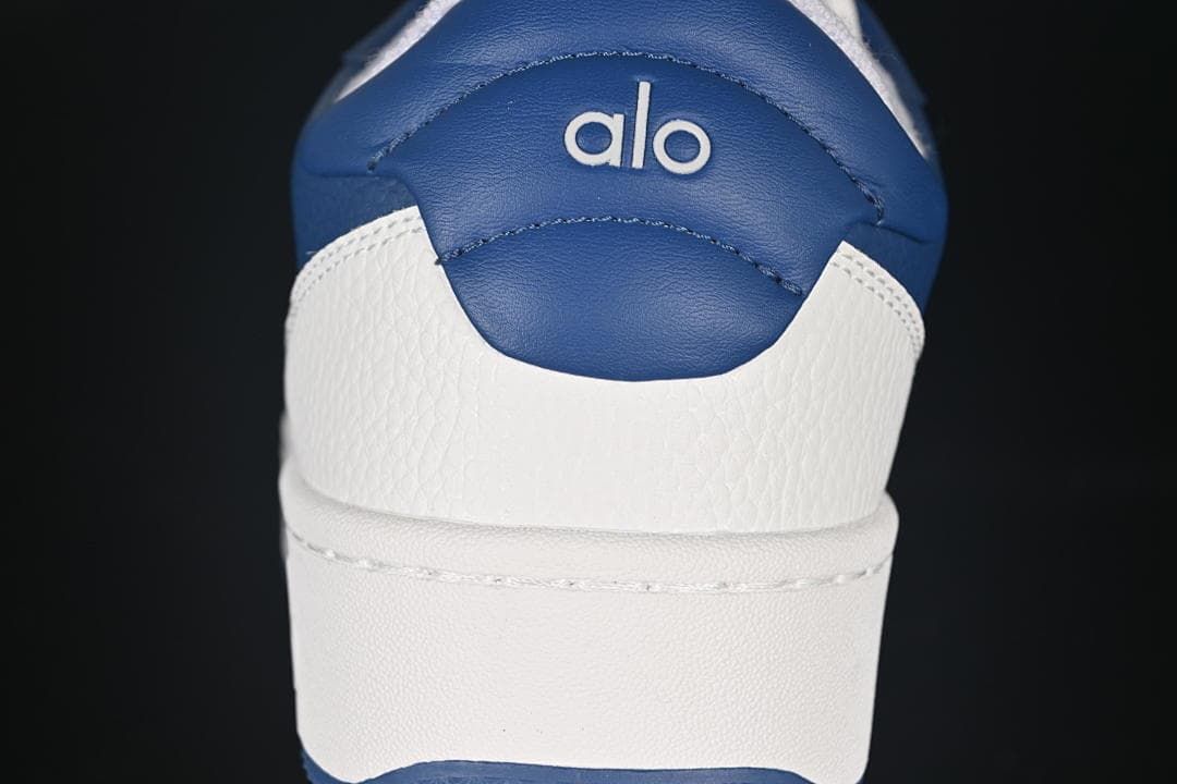 Rear view of the sneaker with navy heel panel and Alo logo