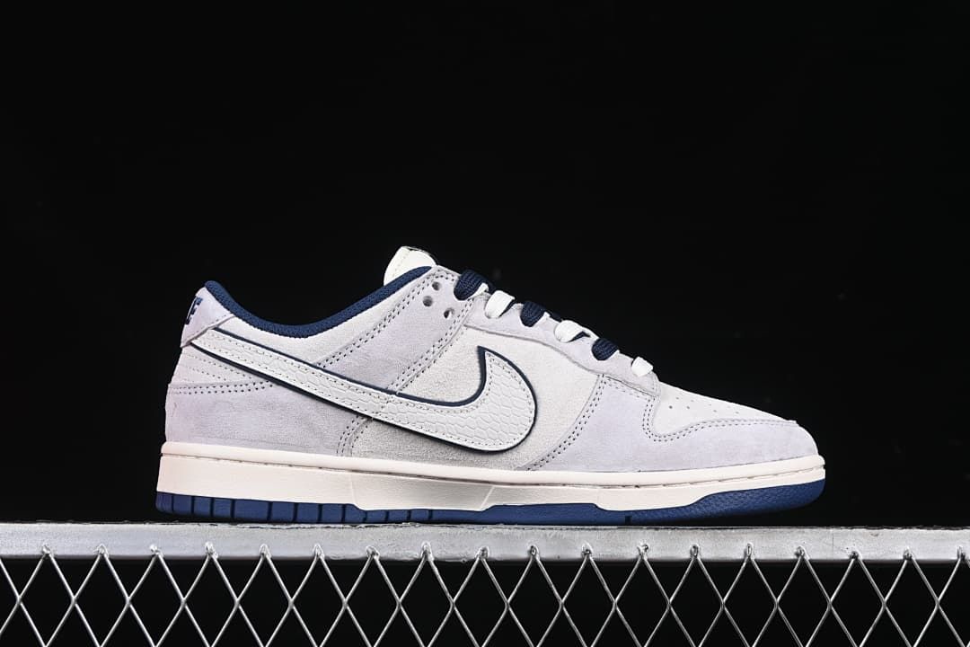 Side profile of the low-top sneaker with light panels and a navy outsole.
