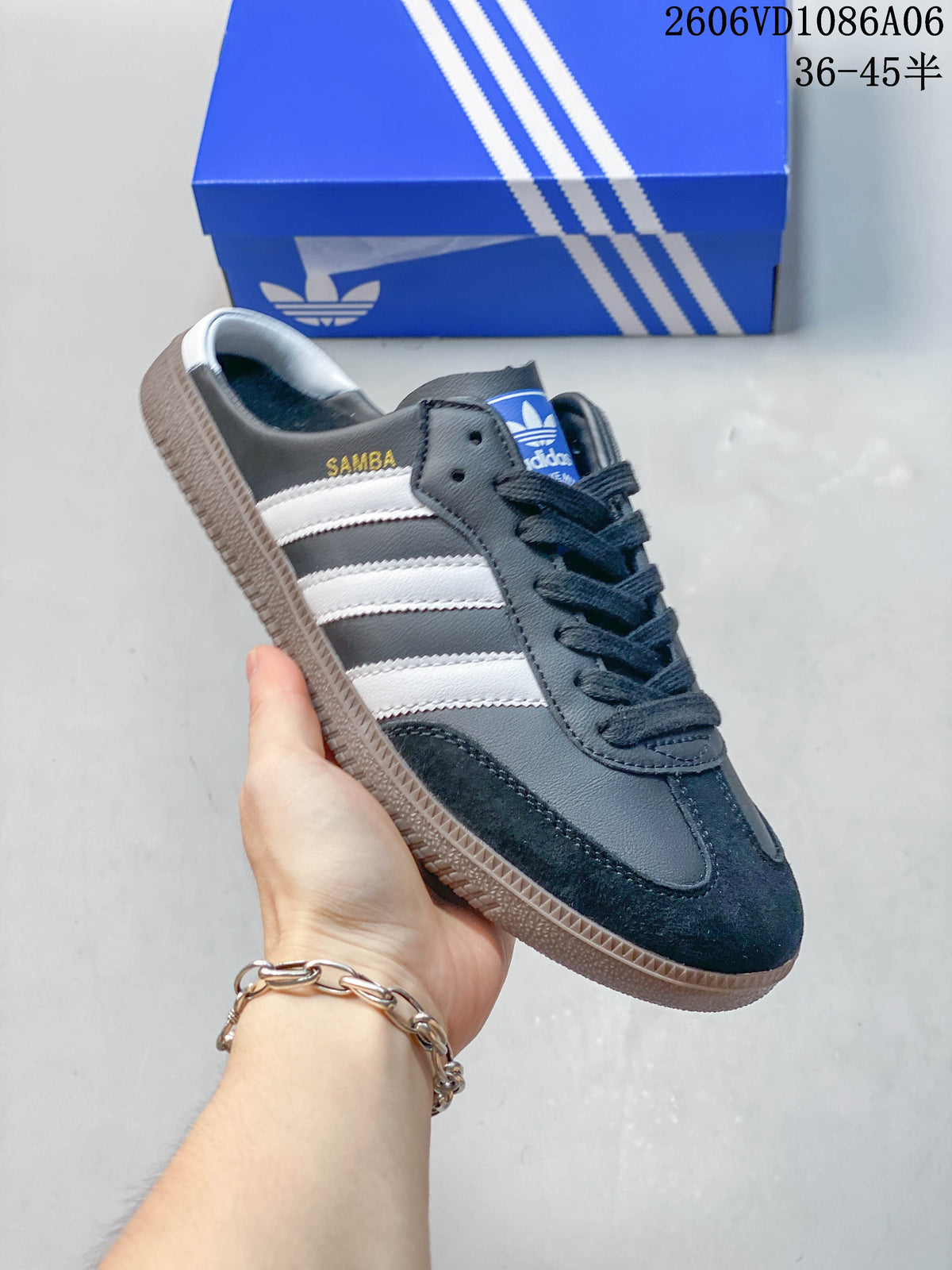 Close-up of a dark gray Samba-style sneaker with white side stripes and a gum-colored outsole.