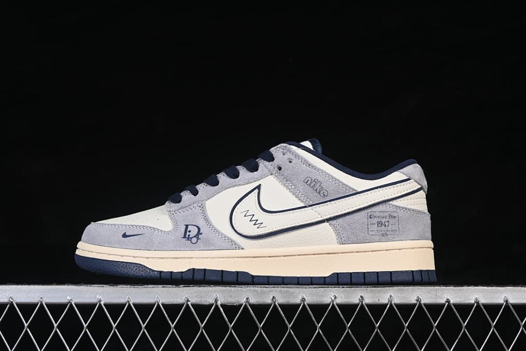 Side view of a grey, white, and navy low-top sneaker with contrast Swoosh detailing