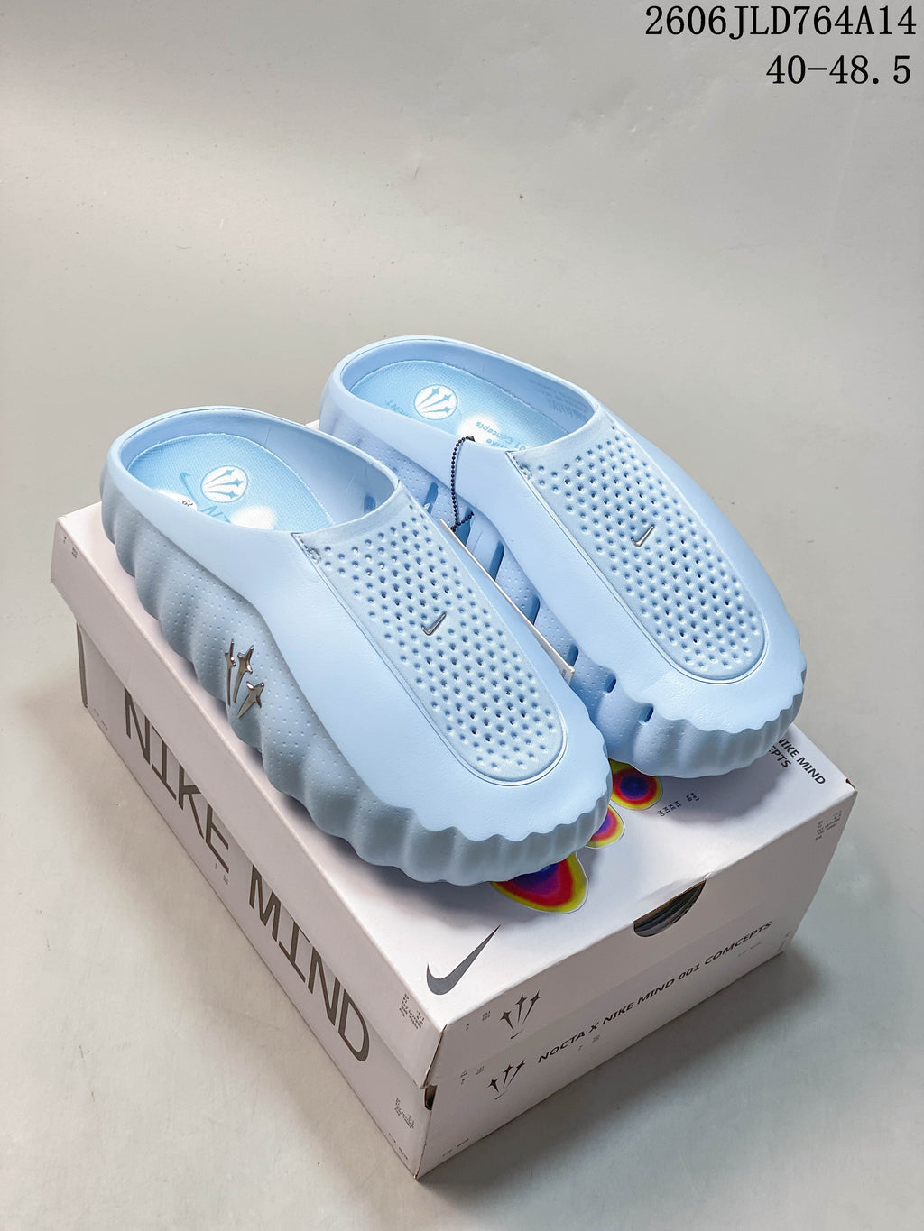 Light blue Nike x NOCTA Mind 001 mule slides displayed on the box