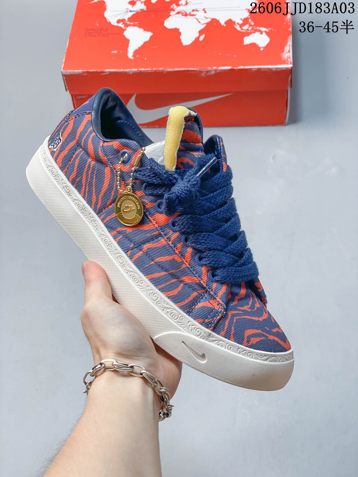Navy and orange patterned low-top sneaker with a white decorated midsole