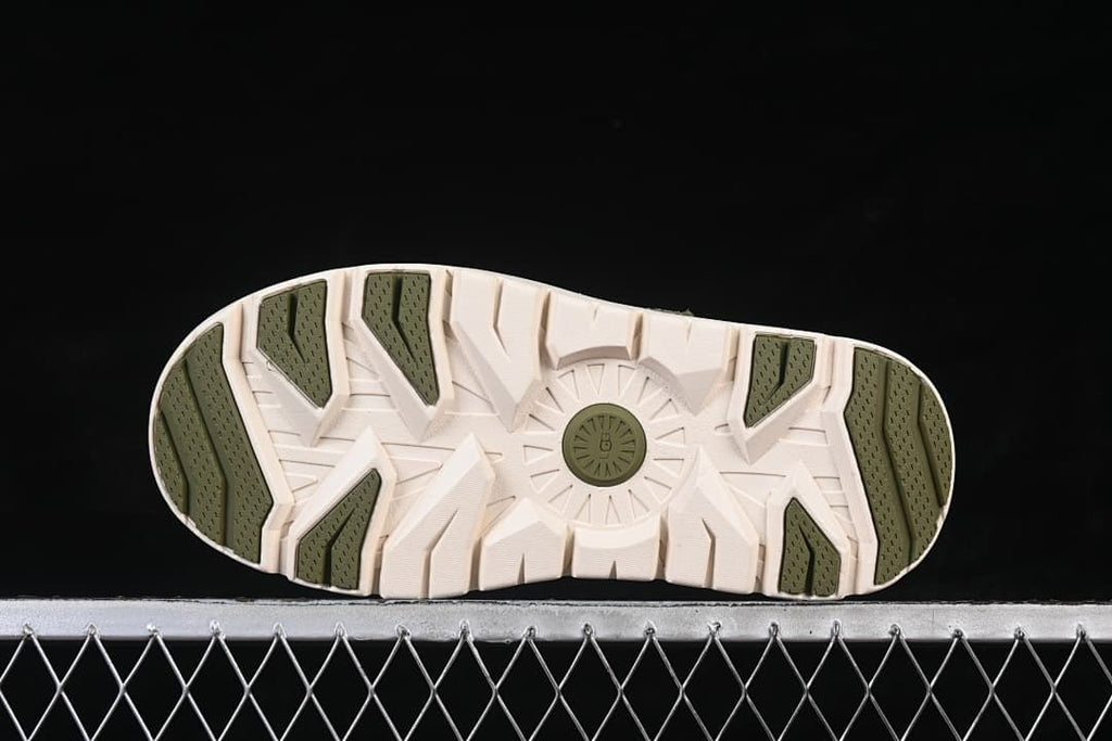 Bottom view of the outsole with green tread sections