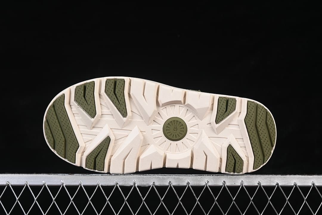 Bottom view of the outsole with green tread sections