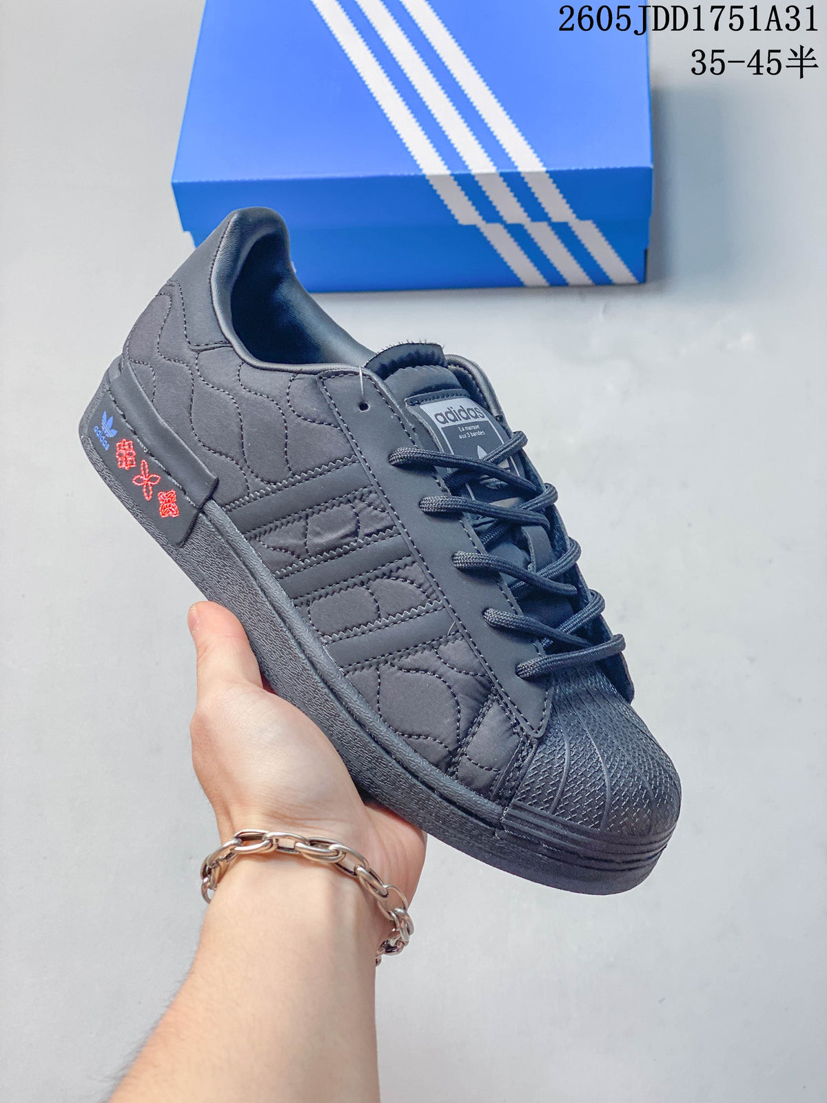 Quilted dark gray sneaker with a shell toe and embroidered heel detail