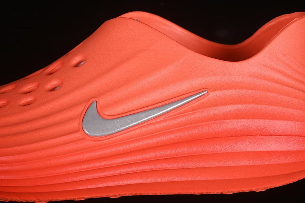Close-up of the Swoosh and ridged side of the orange sandal