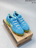 Pair of blue Nike Air VaporMax-style running shoes with white laces and translucent lime-green soles on a box